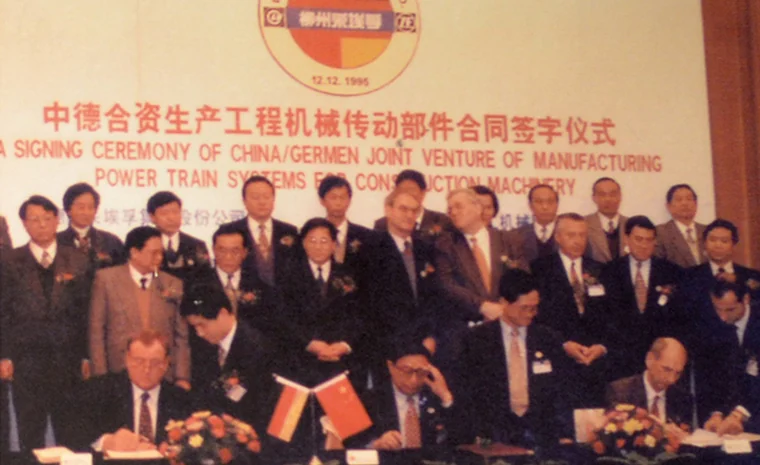 A cerimônia de assinatura da parceria com o Grupo ZF, com as bandeiras da China e da Alemanha